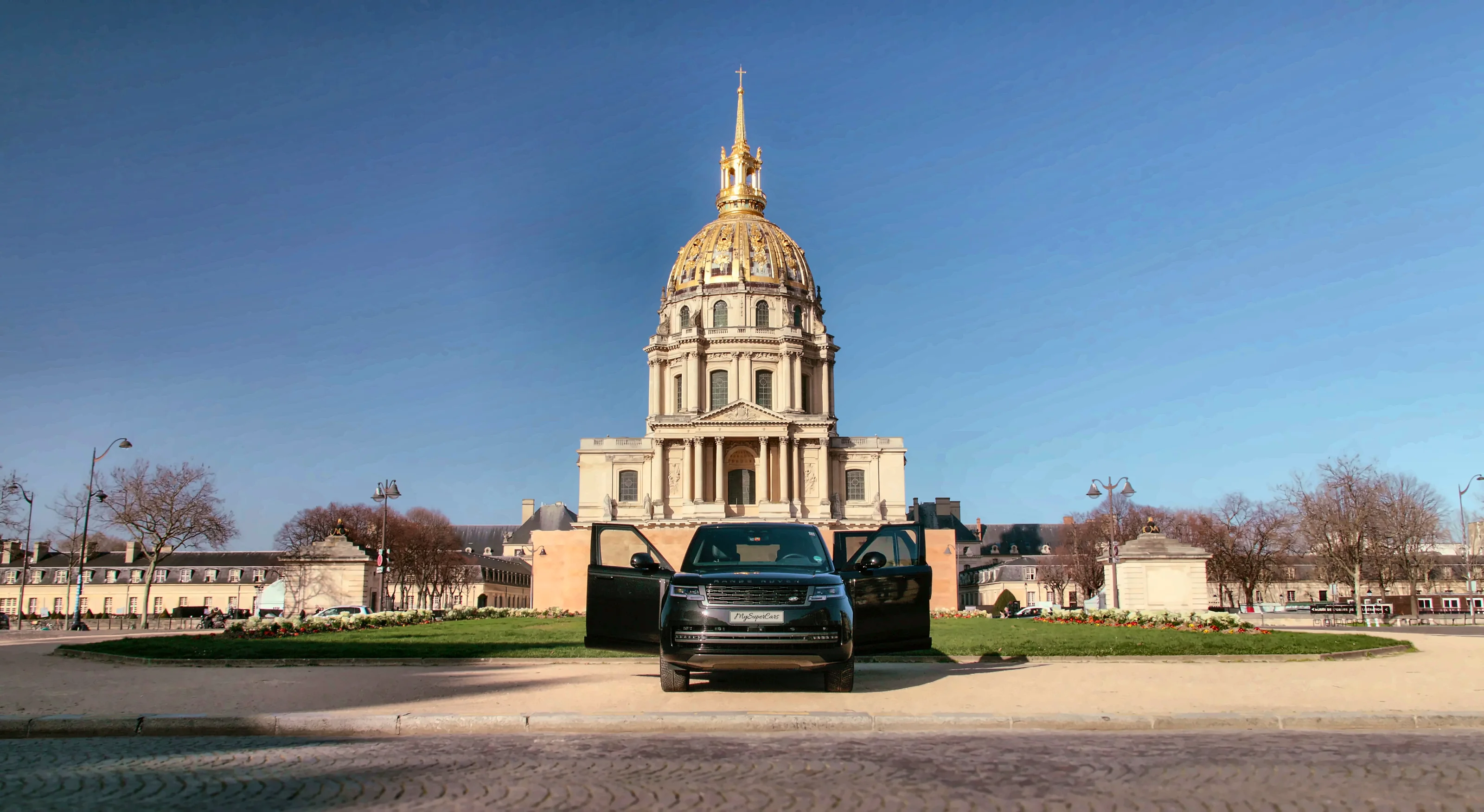 Range Rover noir, portes ouvertes, devant le dôme des Invalides à Paris